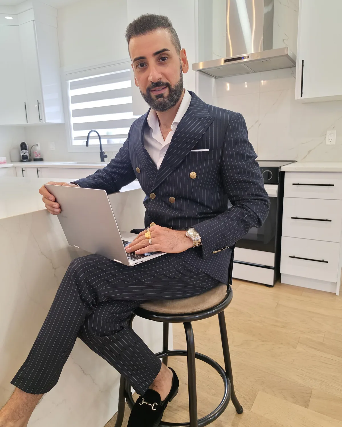 Ghassan Ashag using a laptop in a modern Windsor home kitchen